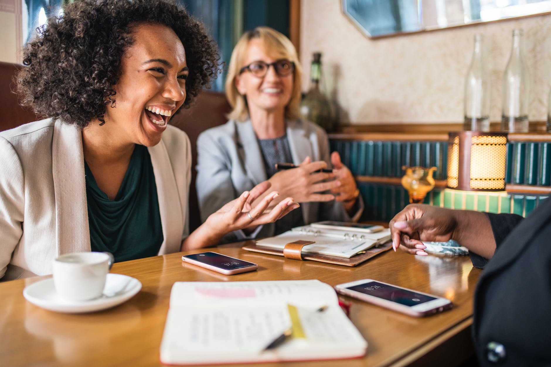 three peple having conversation on table near wall